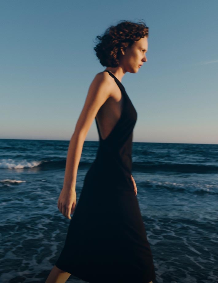 Woman on a beach wearing a long black dress
