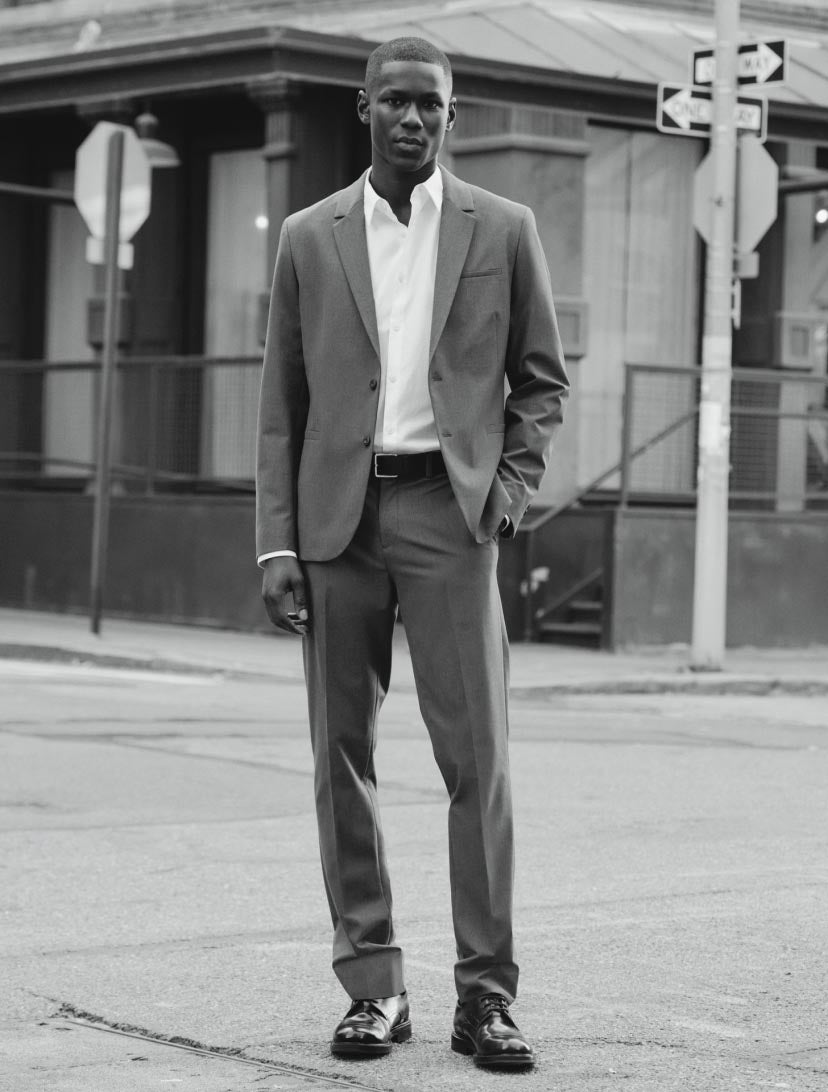 Man standing in the street wearing a grey suit