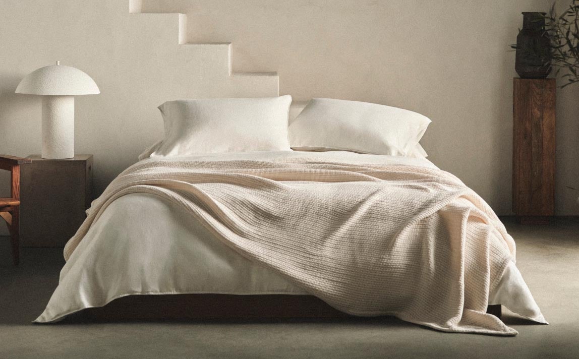 A bed with white Calvin Klein bedding