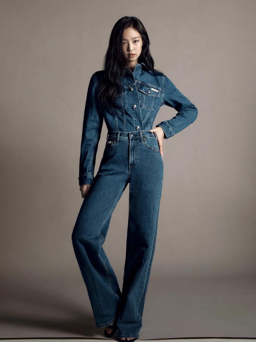 JENNIE posing with her hand on her hip wearing a matching blue denim jacket tucked into blue denim wide leg jeans