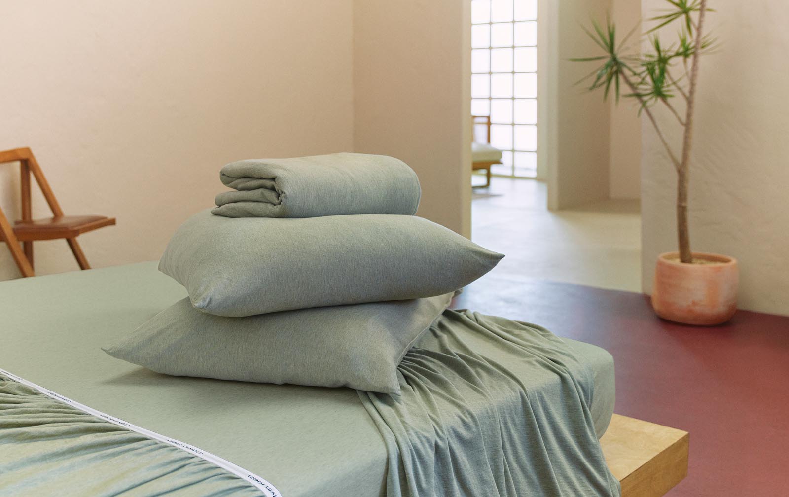 A modern minimalist bedroom featuring soothing bedding.