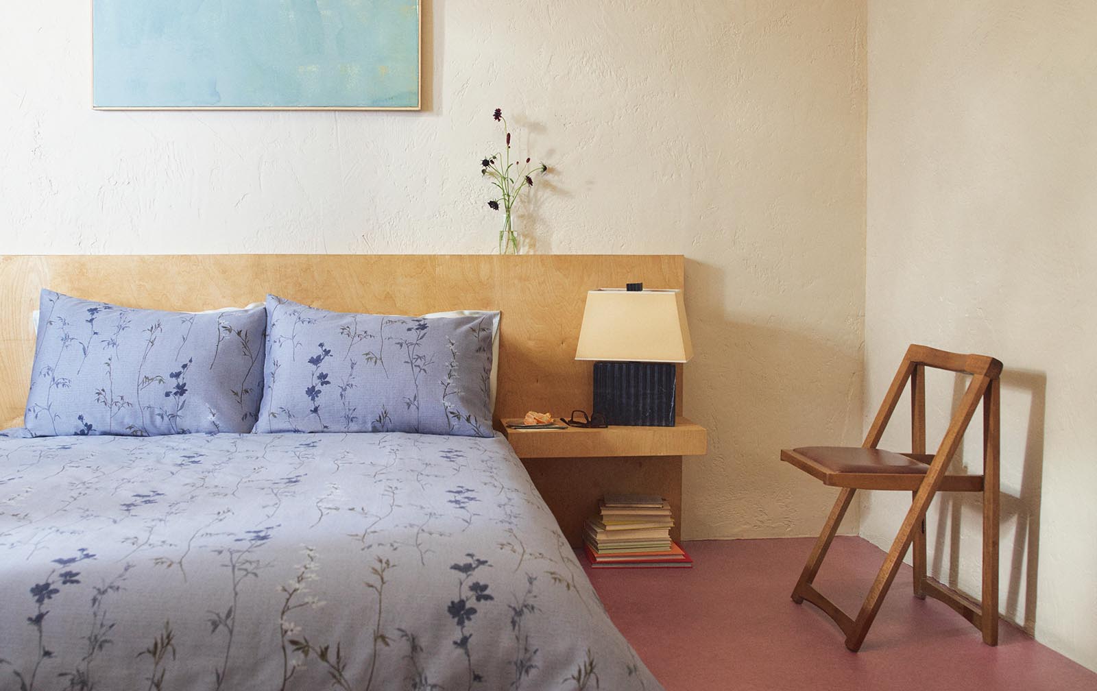 A modern minimalist bedroom featuring blue floral bedding.