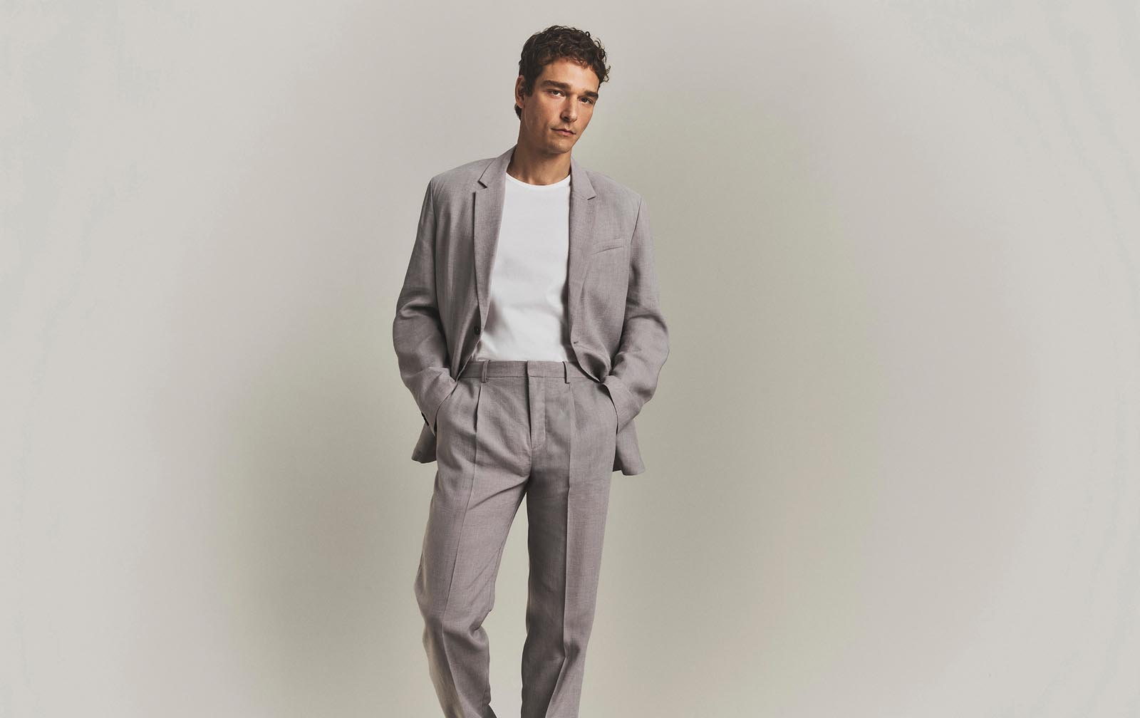 Model posing in a grey suit.