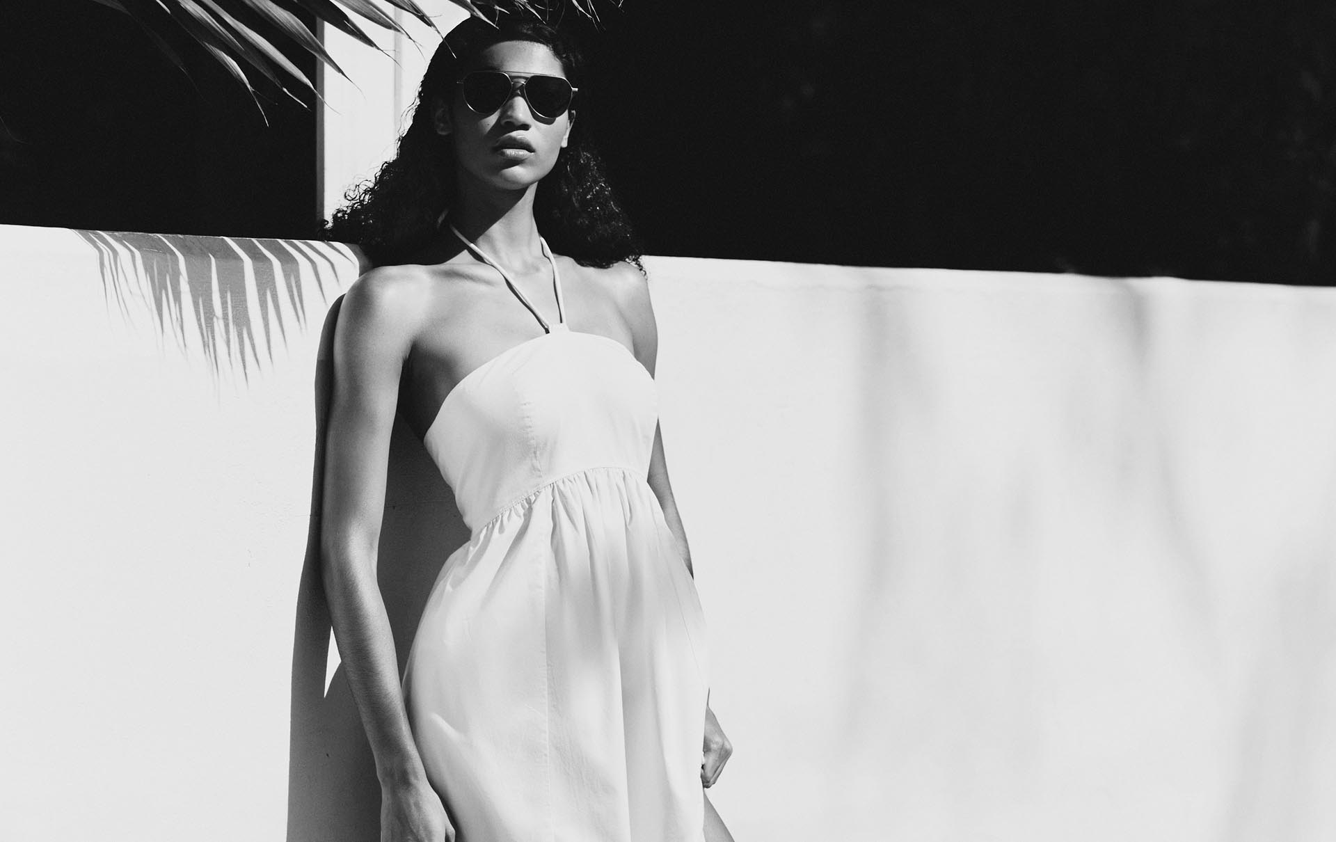 Model posing in a white dress.