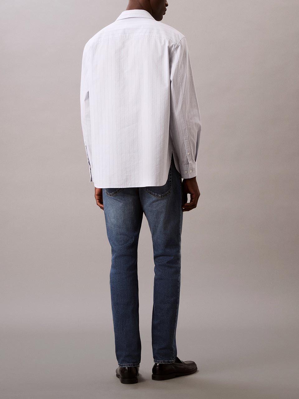 Model wearing head to toe Calvin Klein featuring the slim fit jeans.