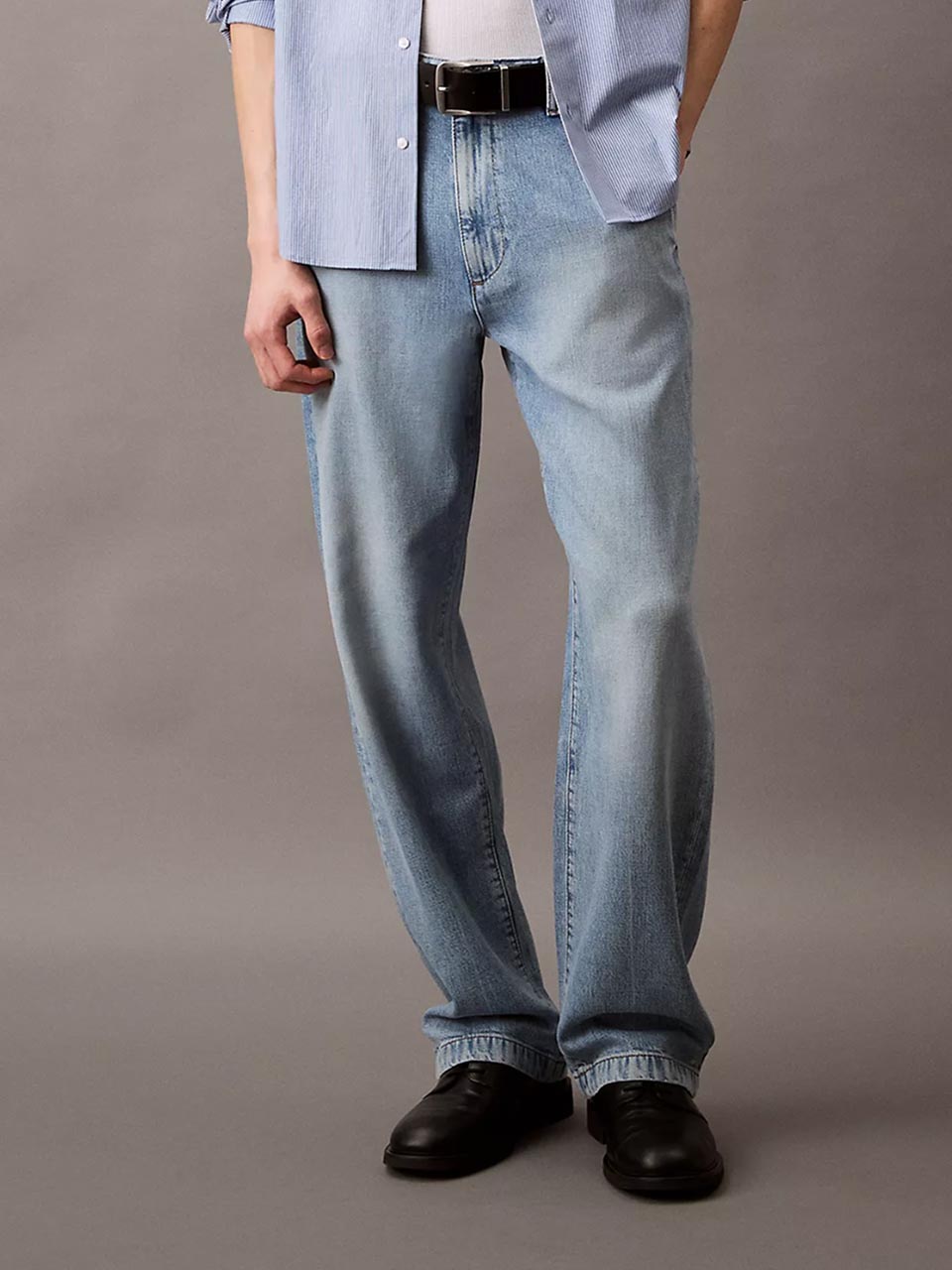 Model wearing head to toe Calvin Klein featuring the standard straight fit jeans.