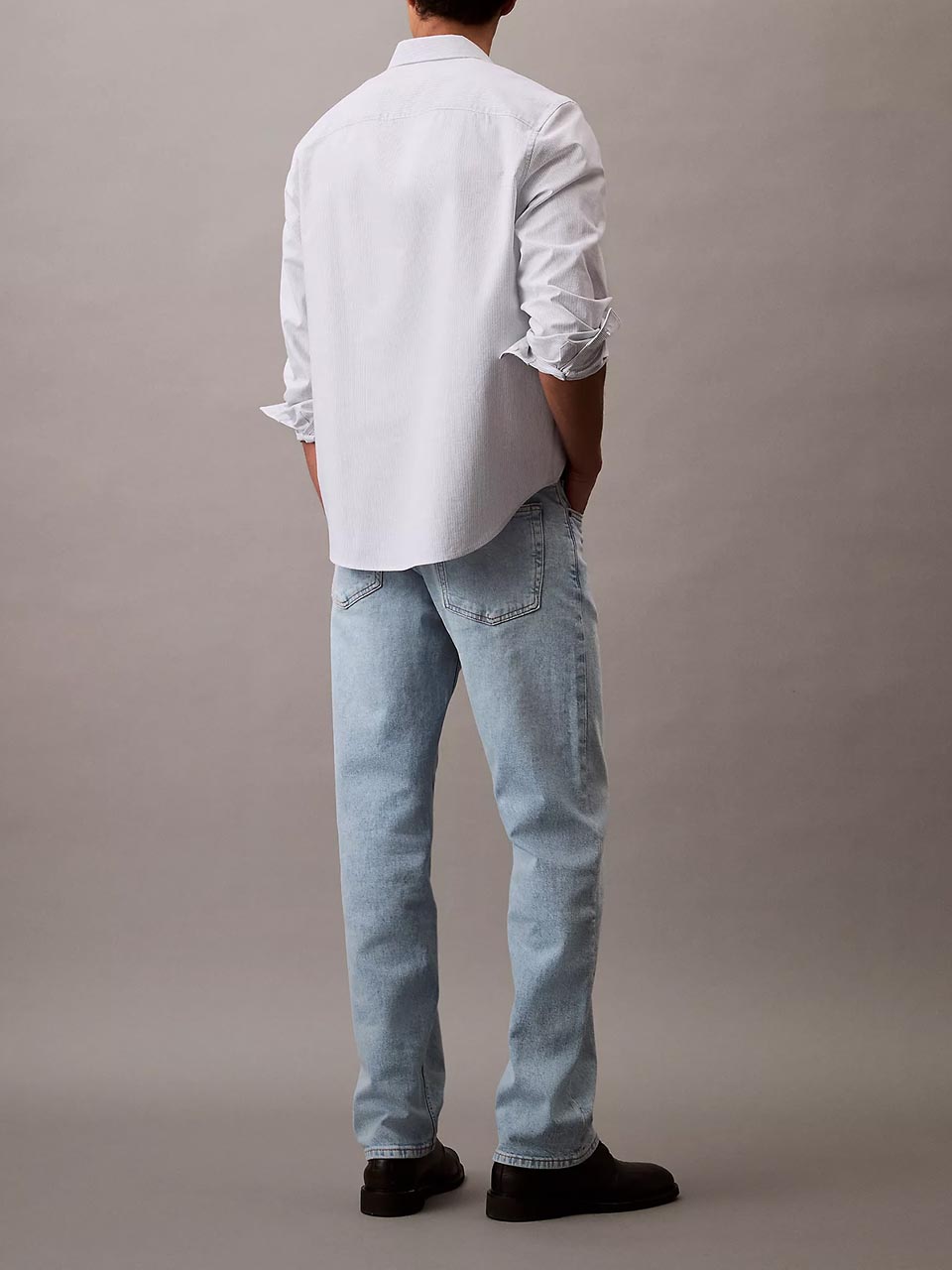 Model wearing head to toe Calvin Klein featuring the standard straight fit jeans.