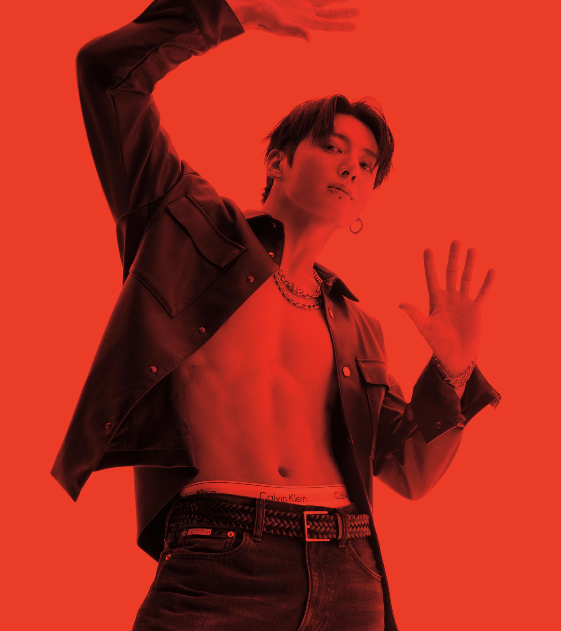 Jung Kook posing in an unbuttoned leather shirt