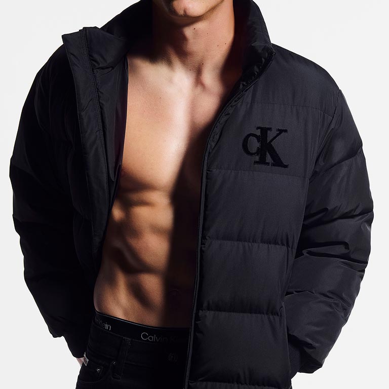 Model posing in a black puffer coat