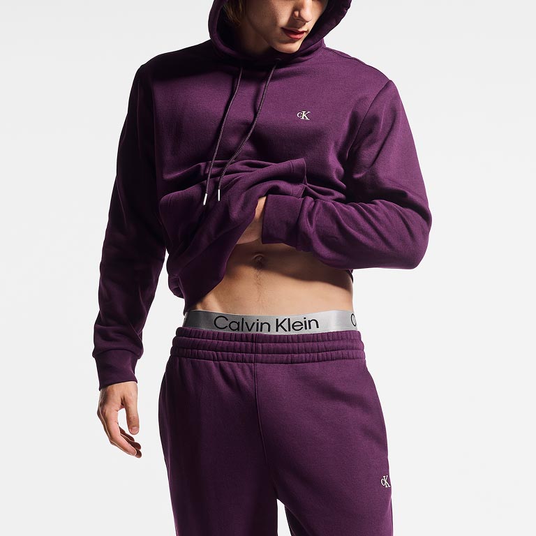 Model posing in a purple sweatsuit
