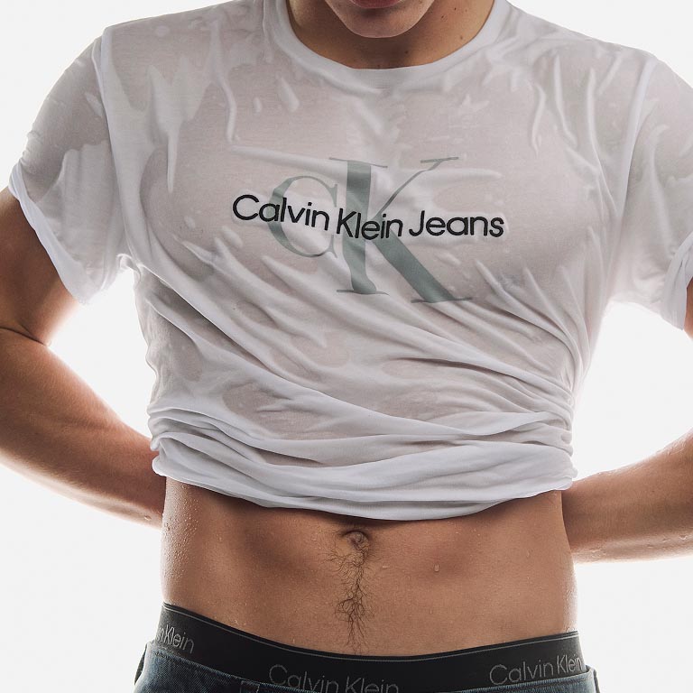 Model posing in a white CK logo t-shirt