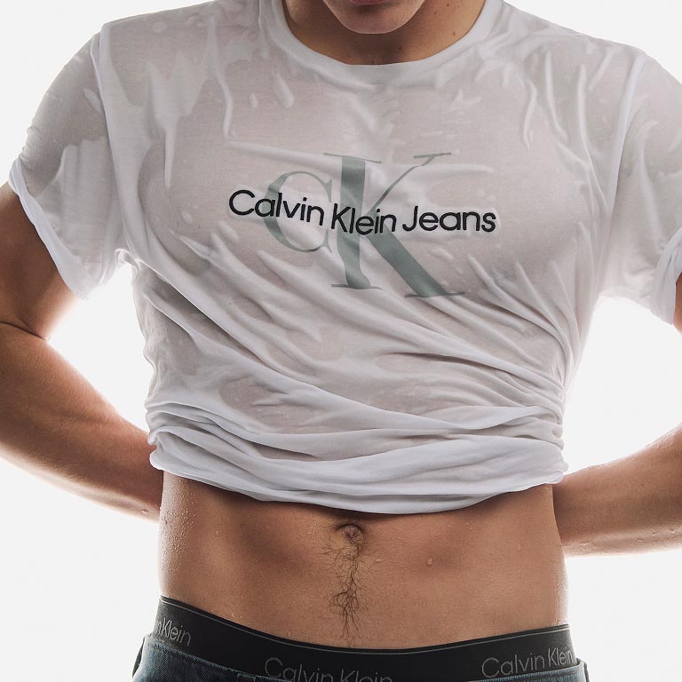 Model posing in a white CK logo t-shirt