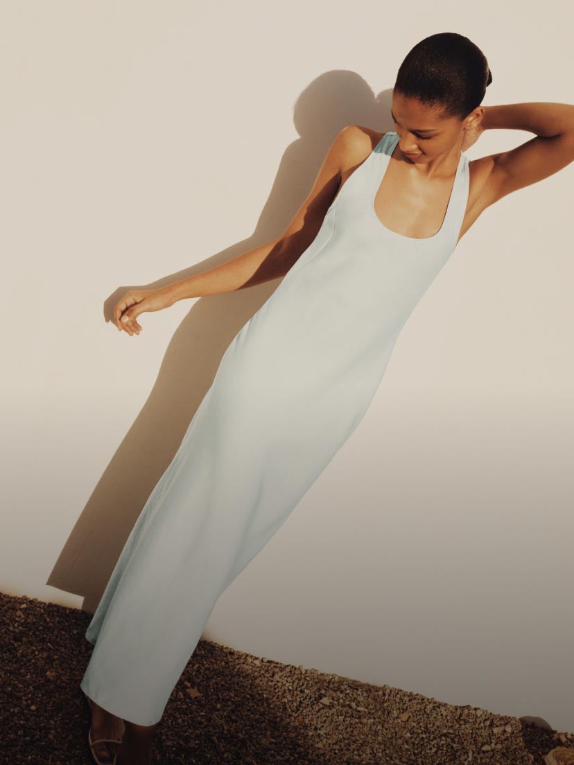 Model posing in a white linen maxi dress