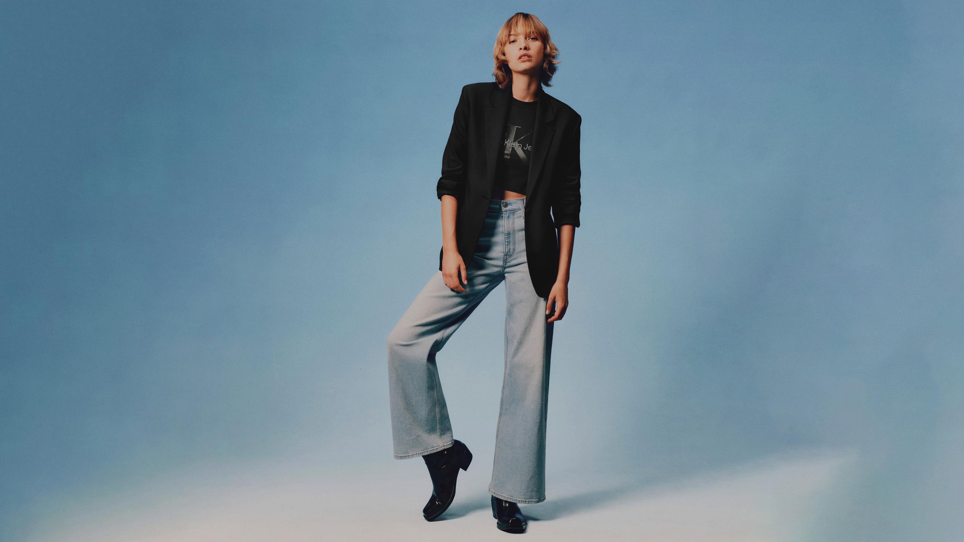 Model posing in high rise wide leg jeans