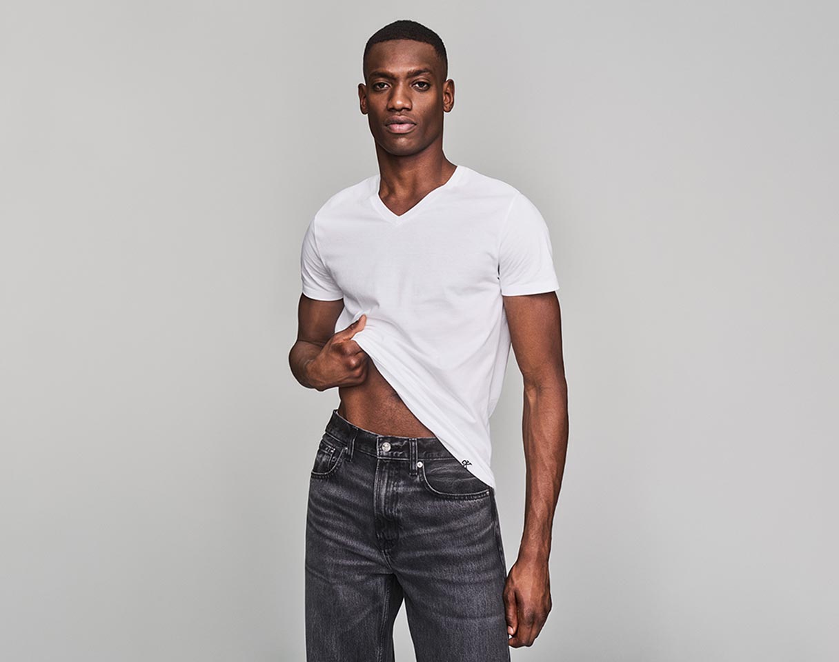 Model posing in a white v-neck tee