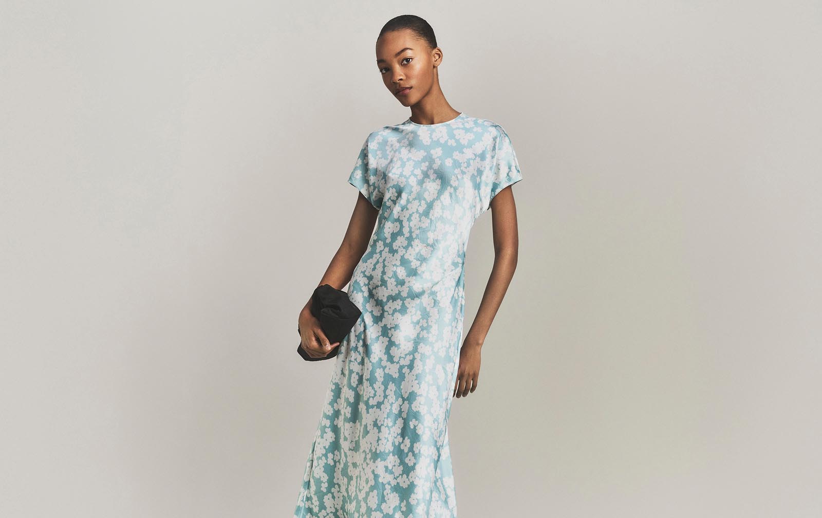 Model posing in a blue floral dress.