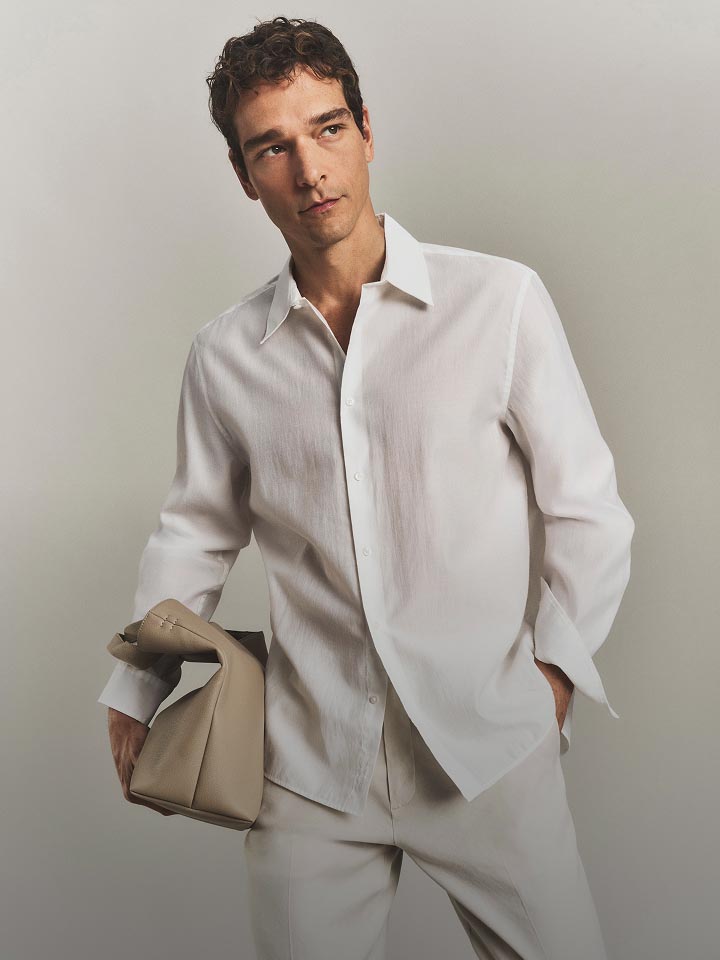 Model posing in a white button-down shirt.