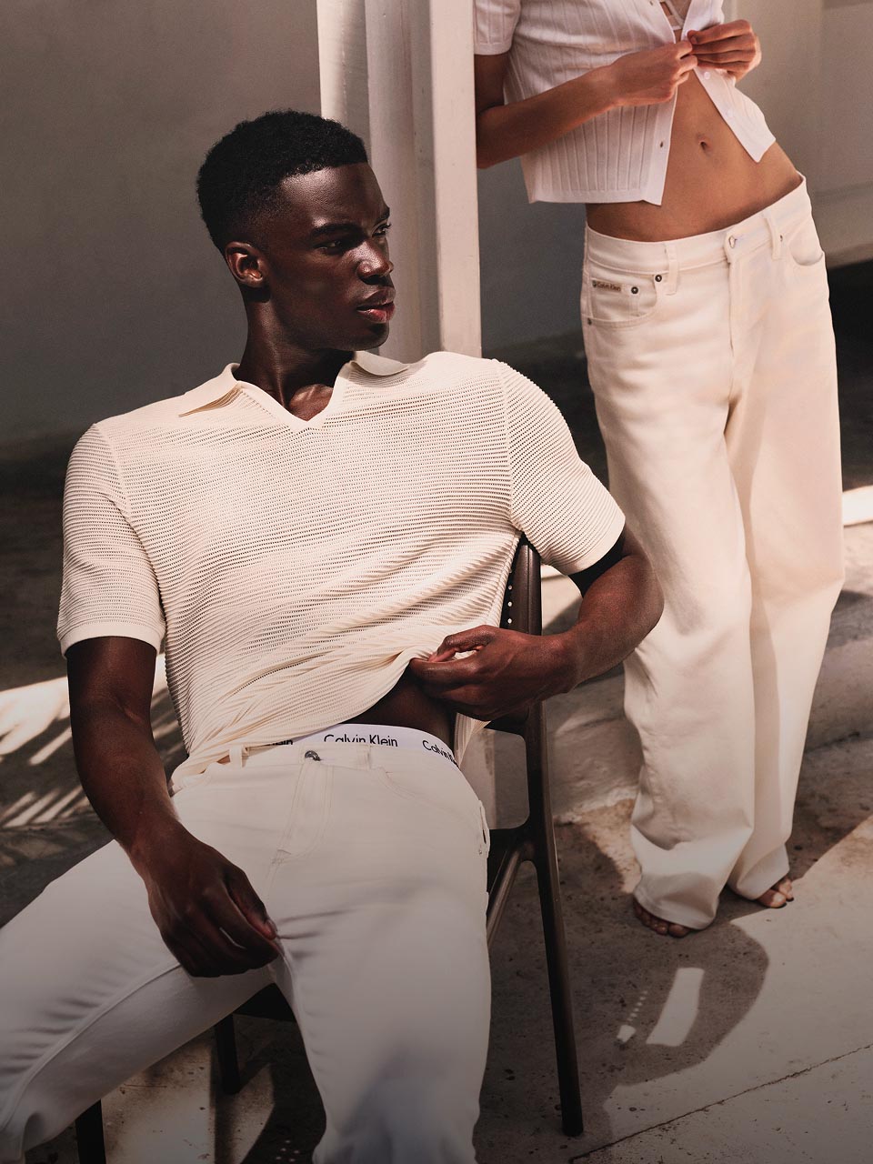 Model posing in a white shirt and khaki pants.