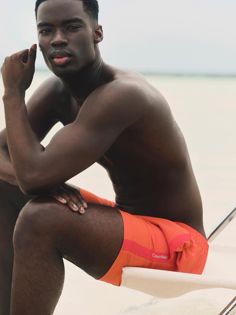 Model posing in an orange swimsuit.