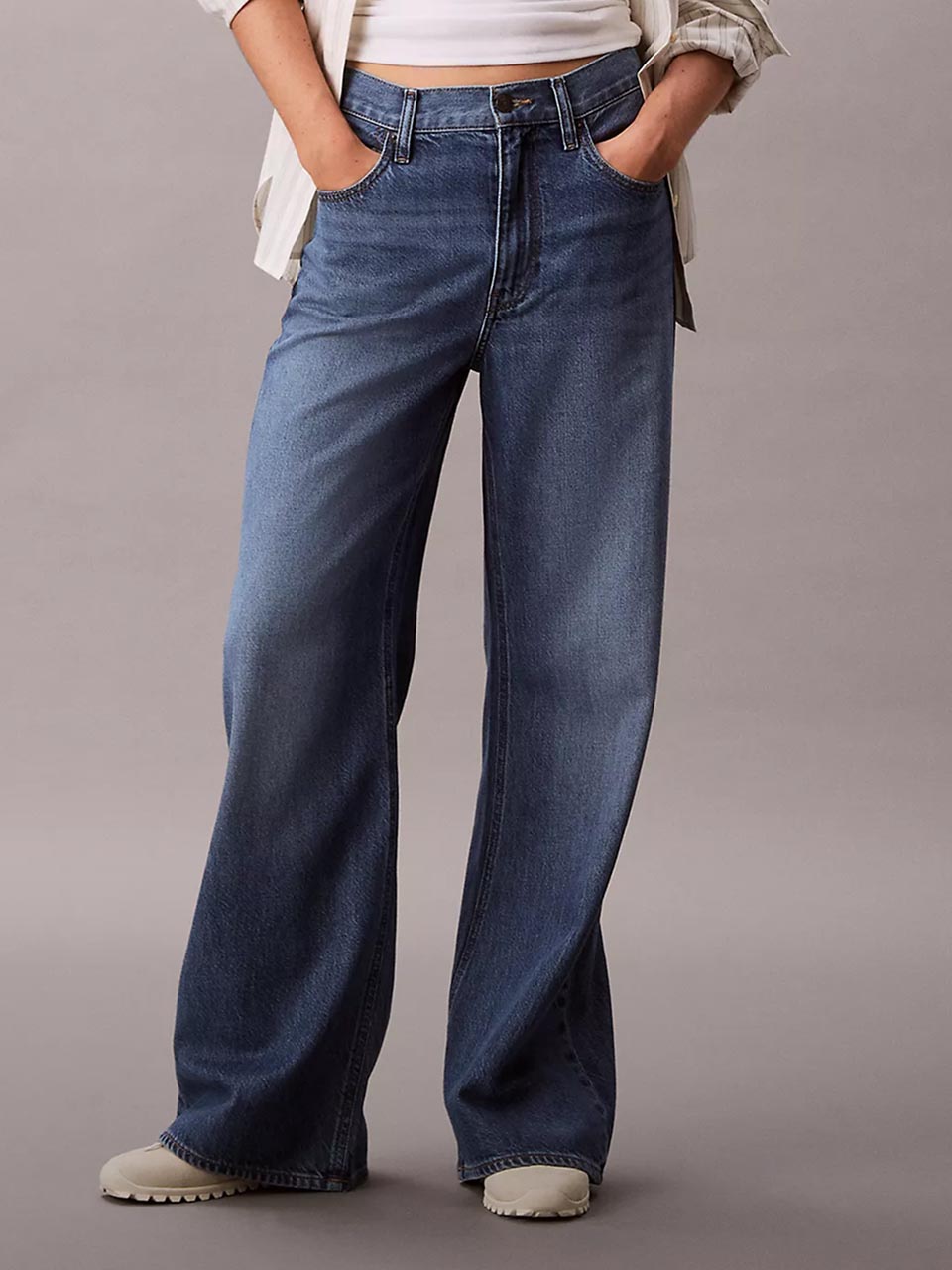 Model wearing head to toe Calvin Klein featuring the high rise flare jeans.
