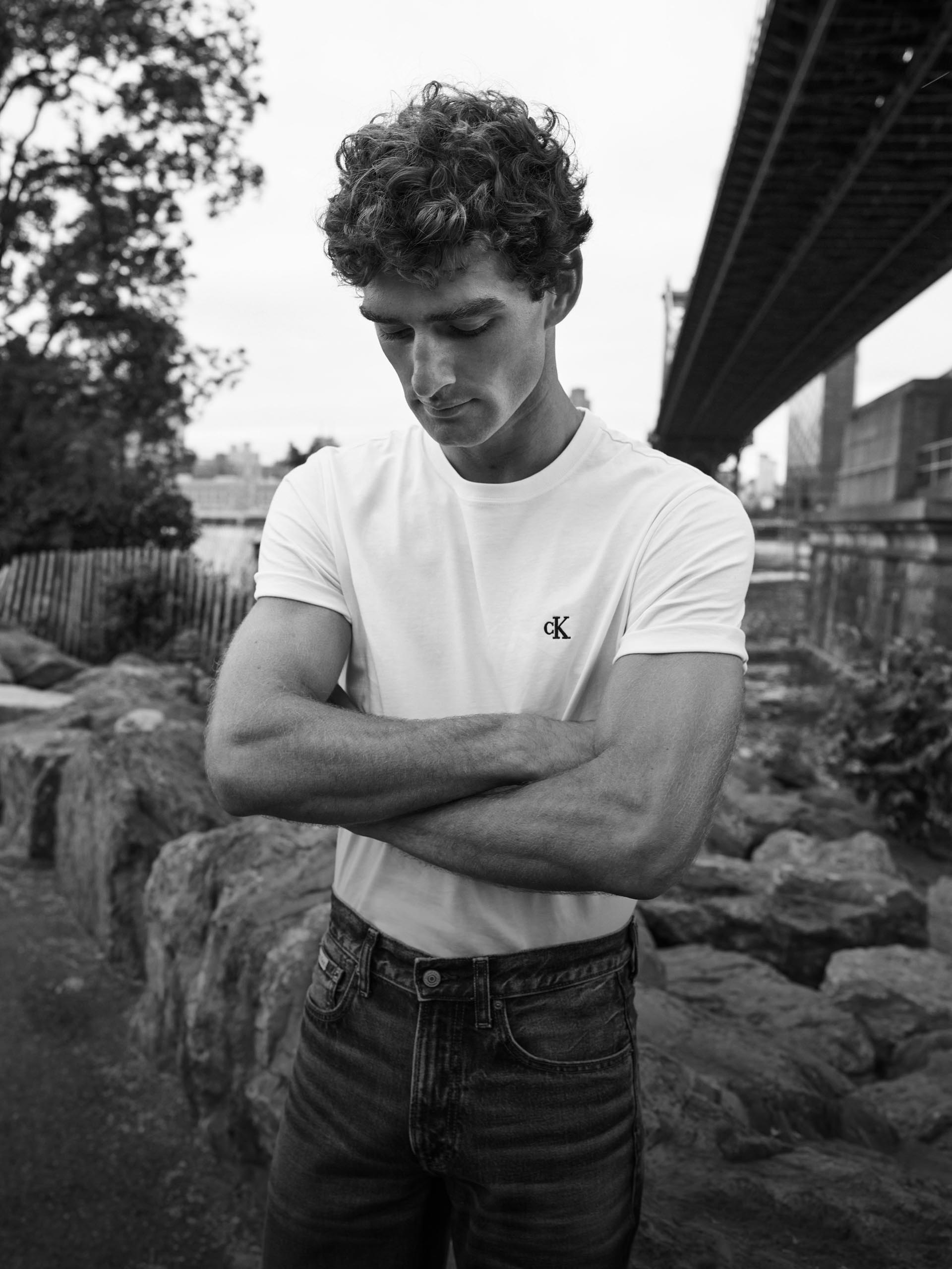Model wearing a white tee with the Calvin Klein logo on the chest.
