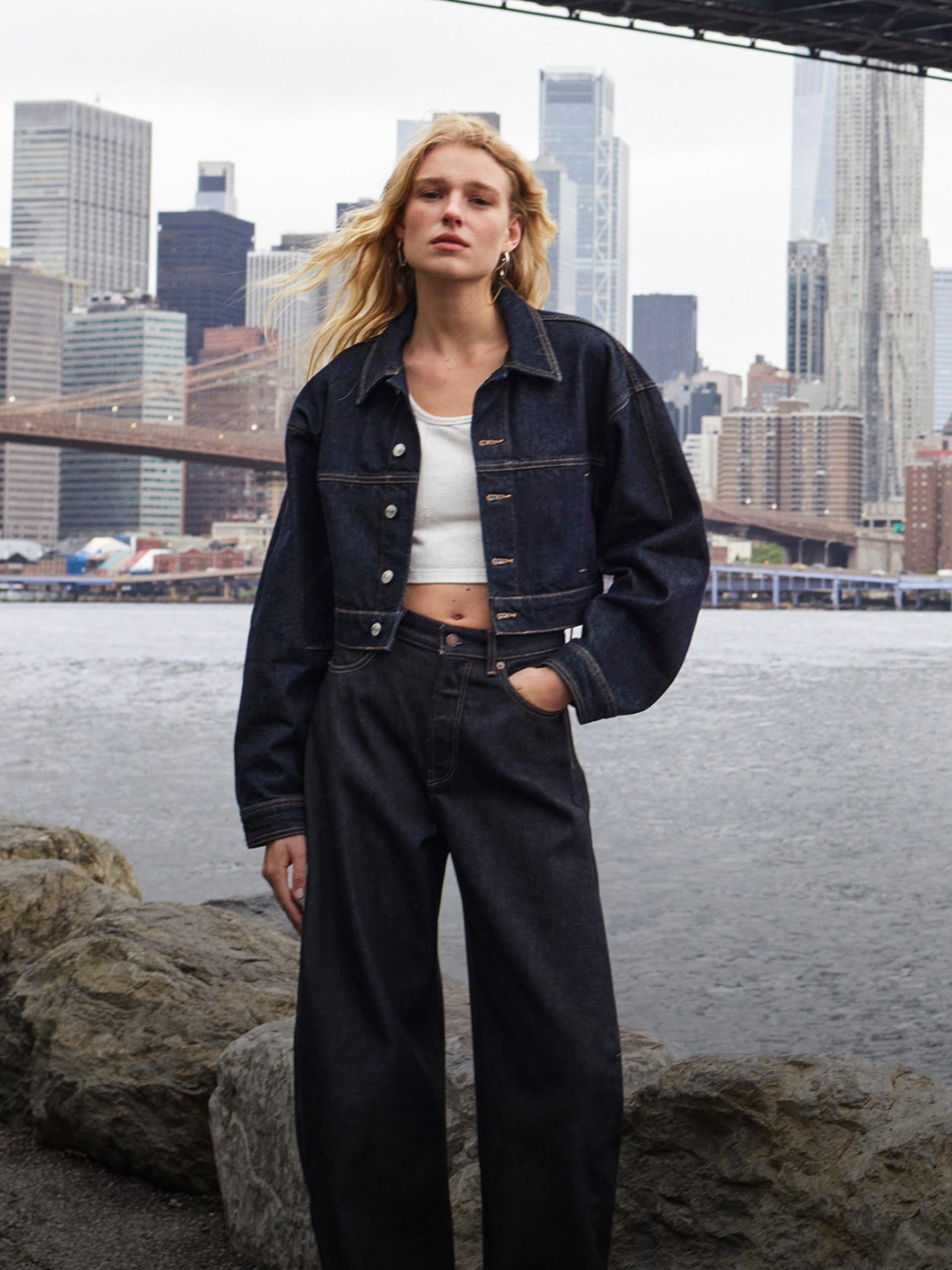 Model wearing a lightweight denim jacket and denim baggy jeans.