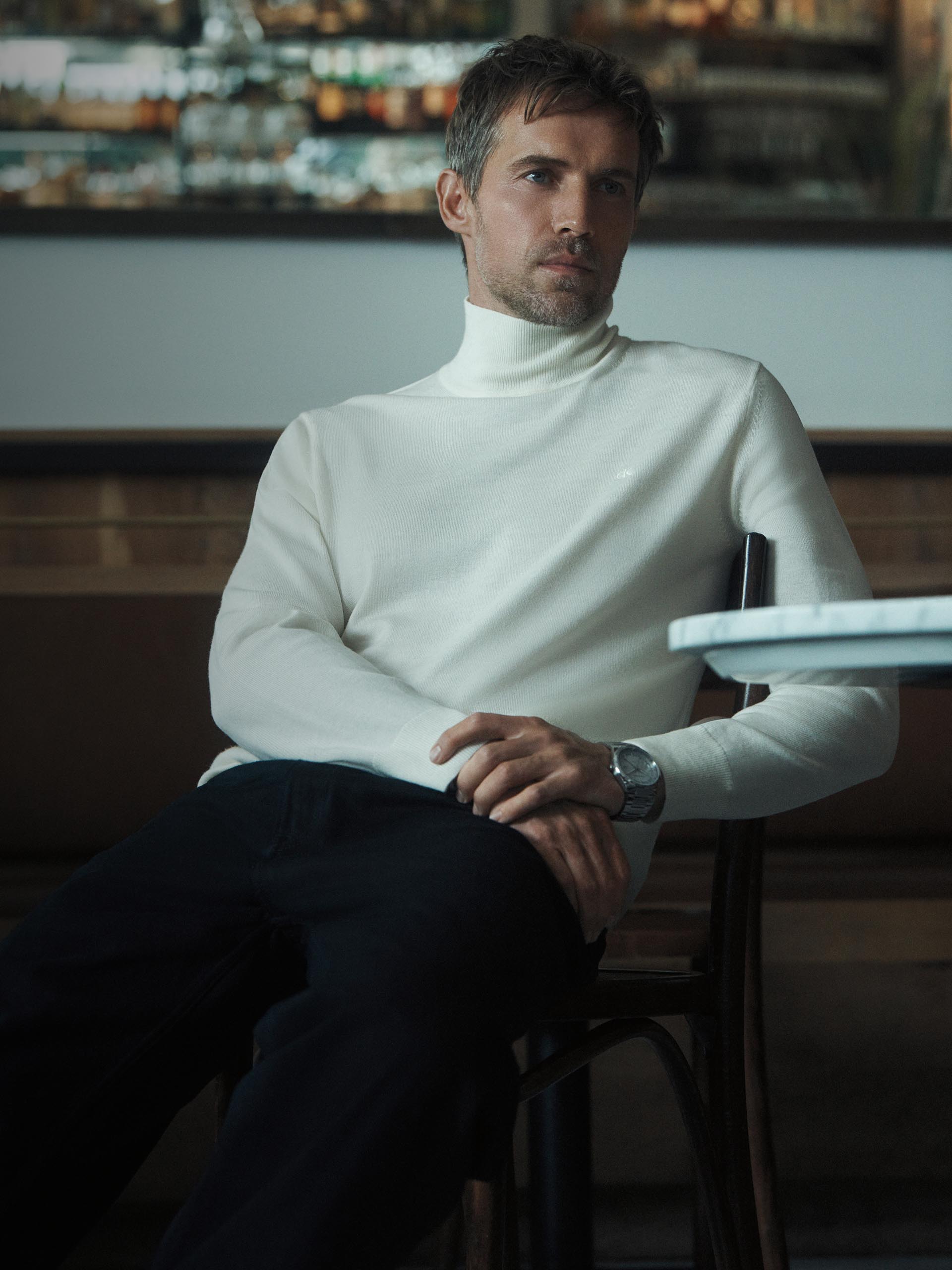 Models posing in white turtleneck sweaters