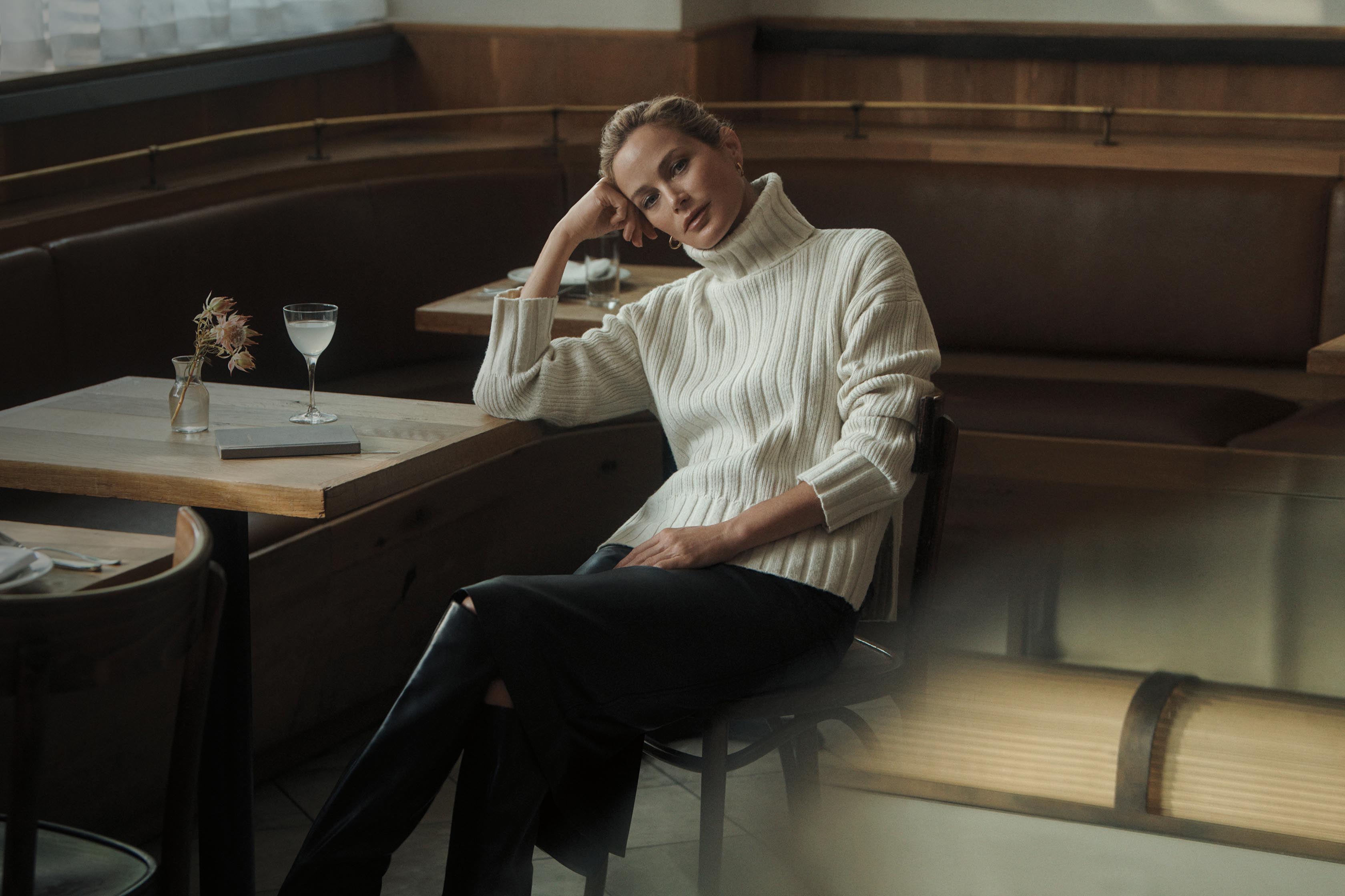 Model posing in a white turtleneck sweater