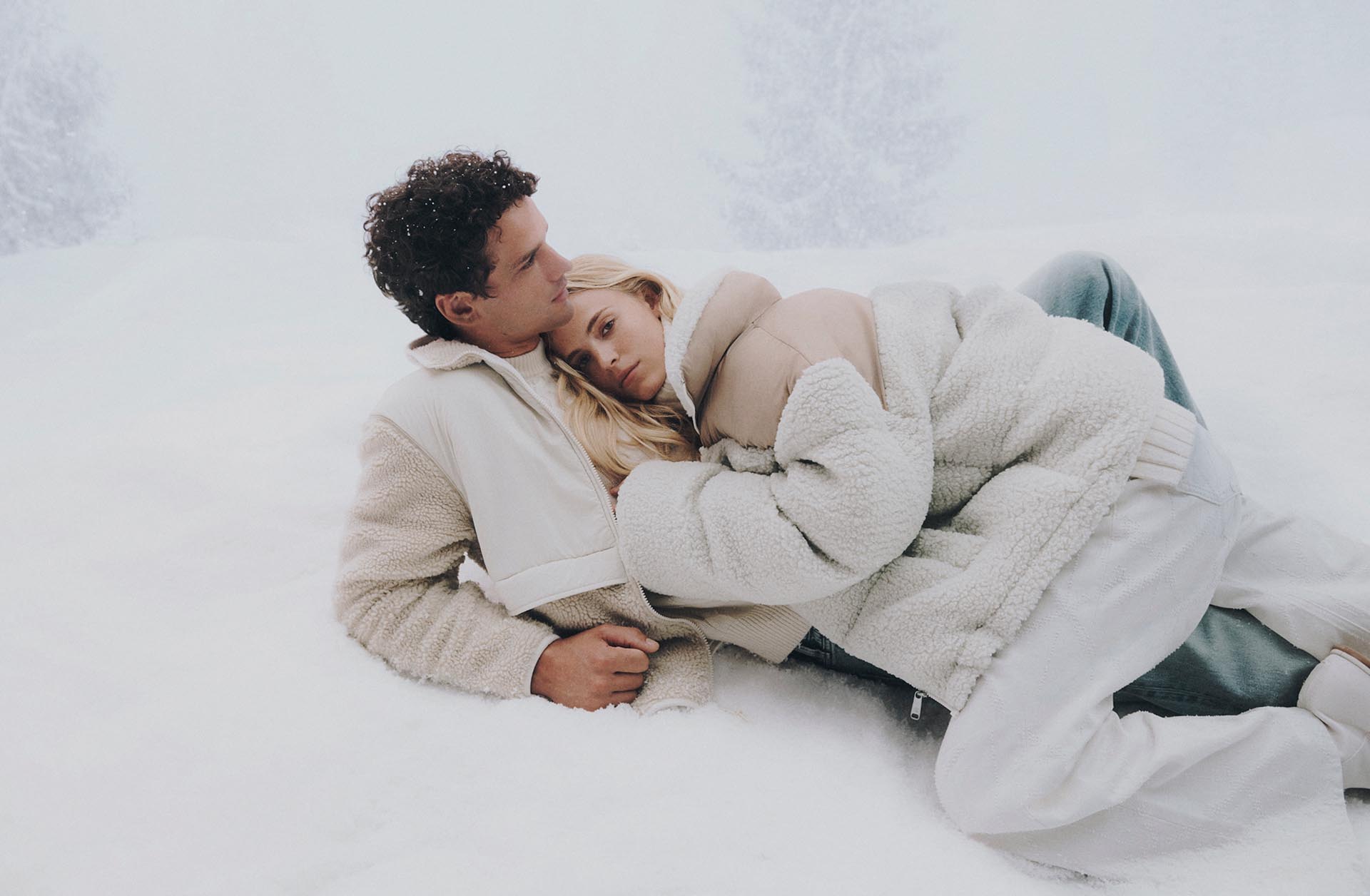 Models posing in the snow wearing Calvin Klein outerwear