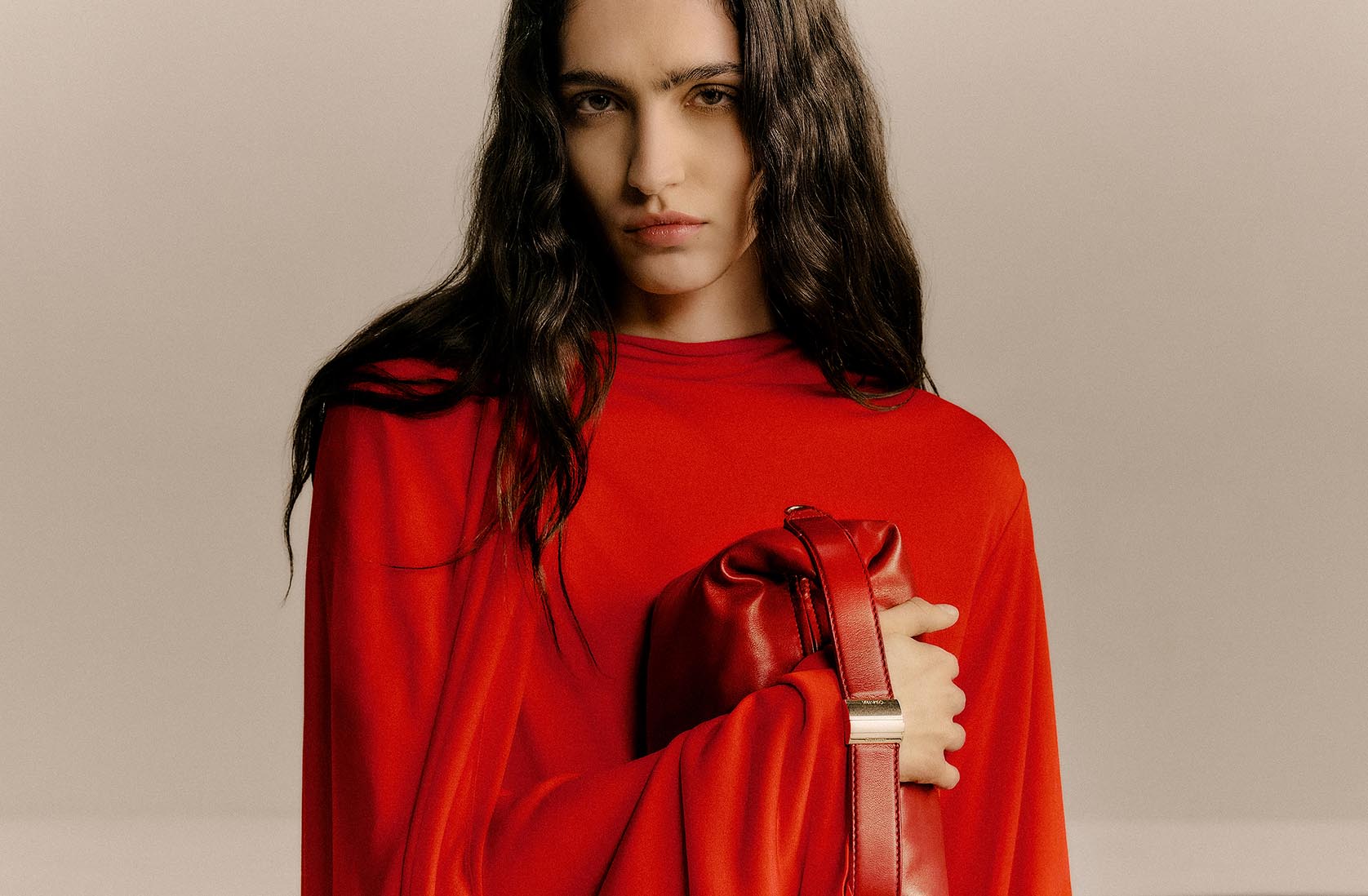 Model wearing a red Calvin Klein Collection evening dress and bag