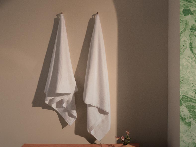 Still life image of white towels hanging on the wall