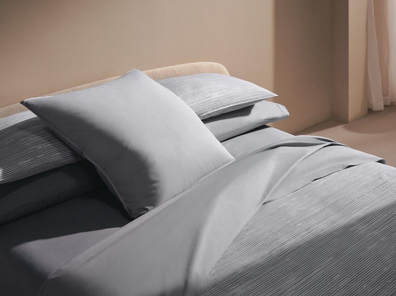 Still life image of a bed with blue sheets and duvet cover