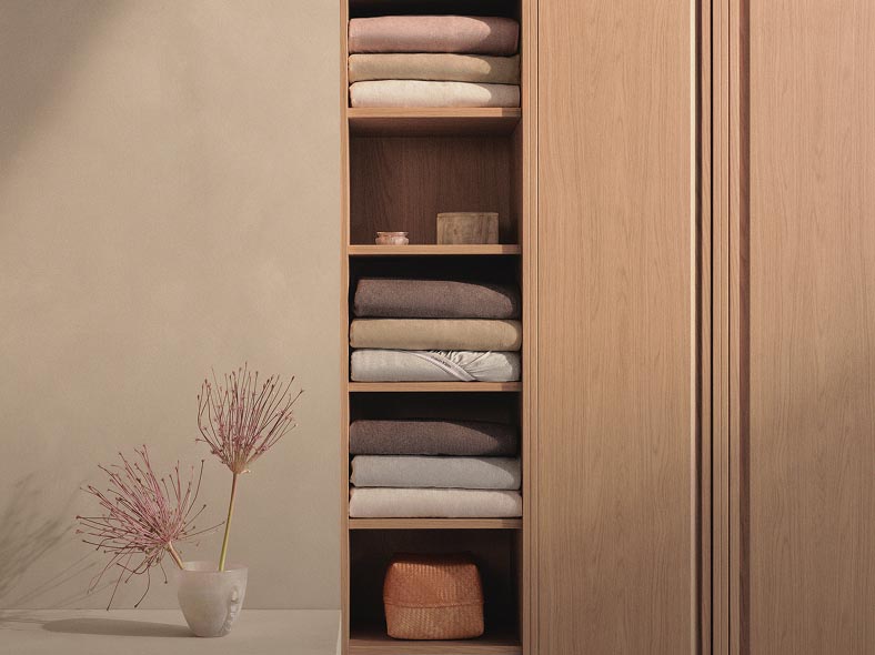 Still life image of a stack of sheets in a closet