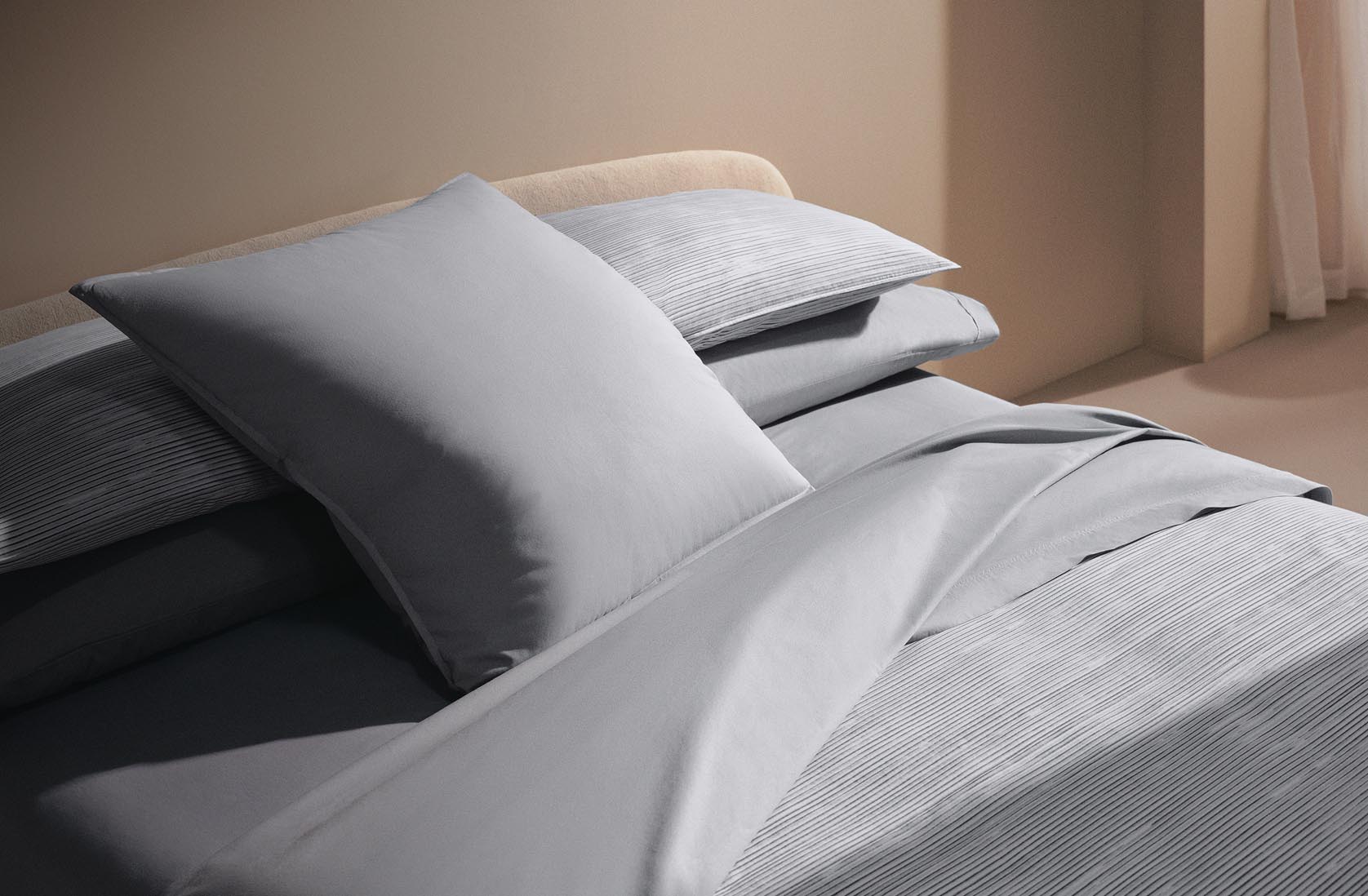 Still life image of a bed with blue sheets and comforter