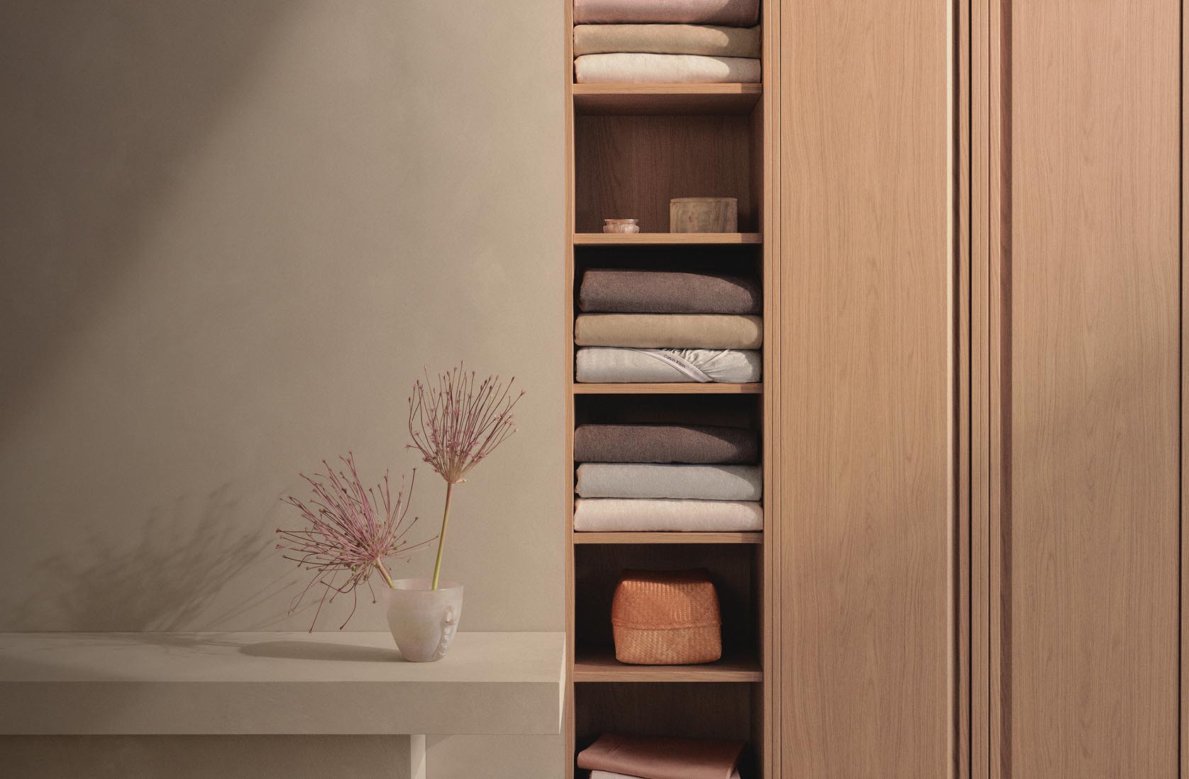 Still life image of a stack of sheets in a closet