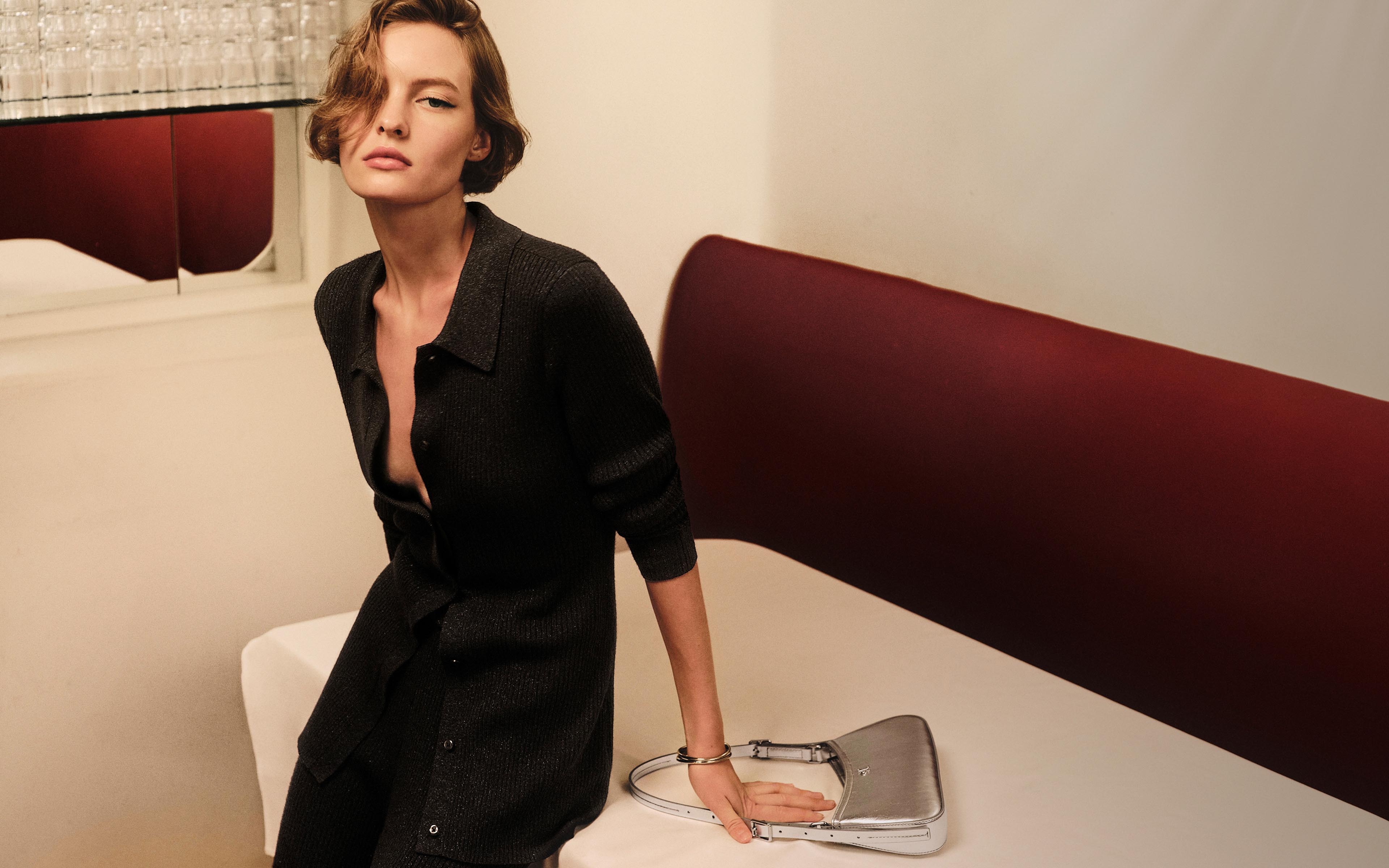 Model posing in a black cardigan sweater