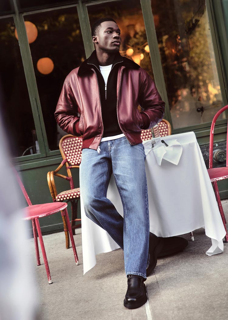 Model posing in a red leather bomber jacket and jeans