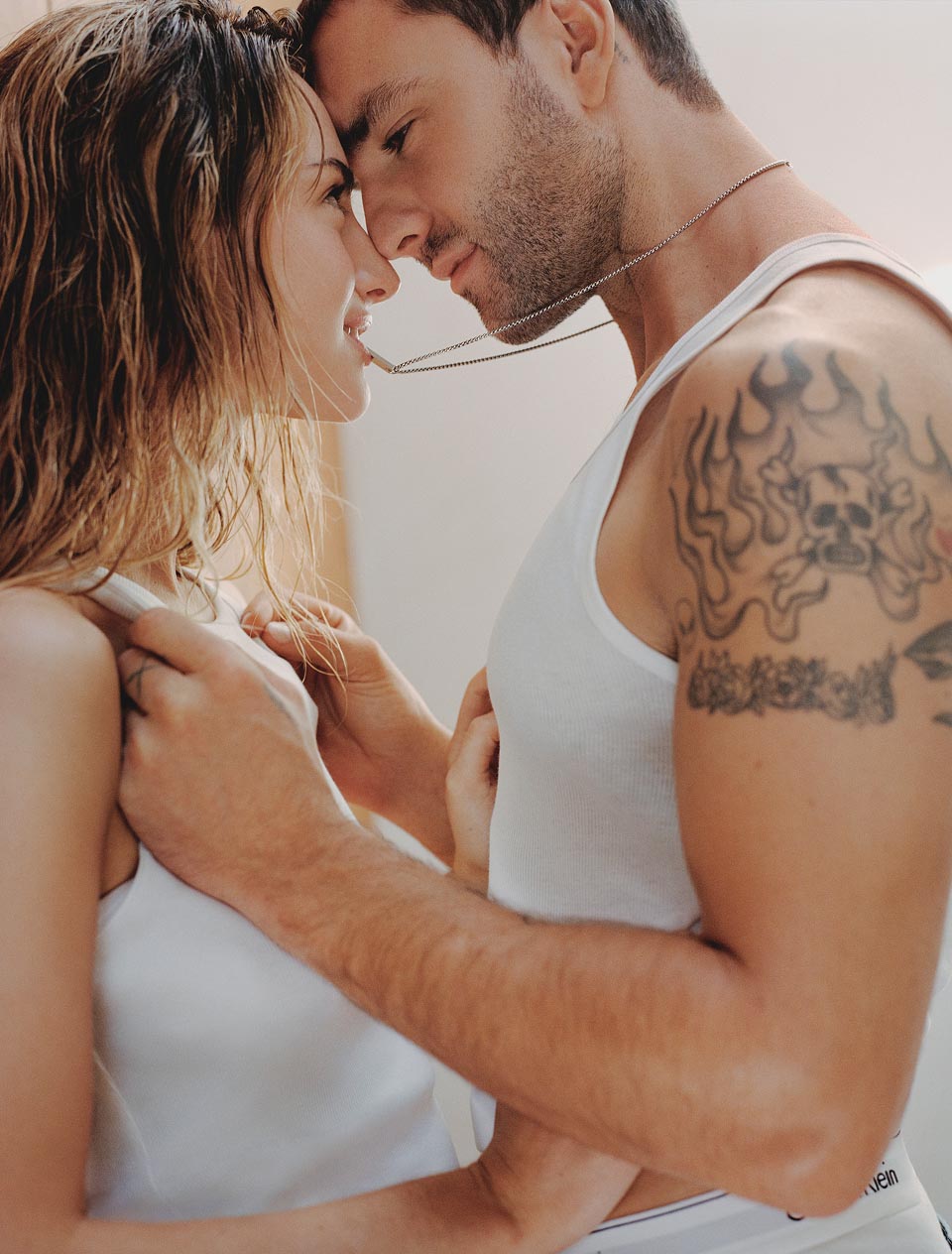 Grace Van Patten posing in a white tank top