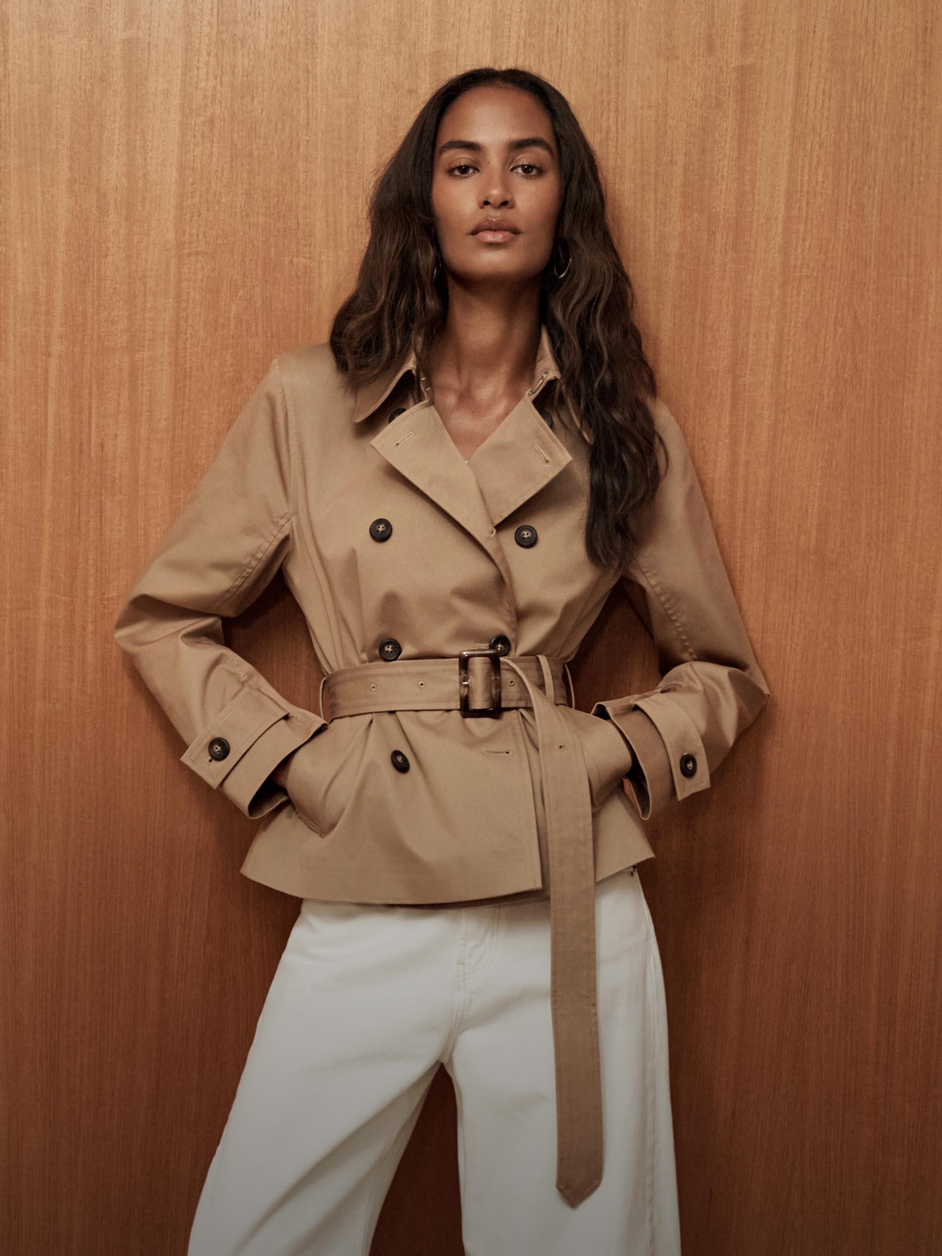 Model posing in a cropped trench jacket