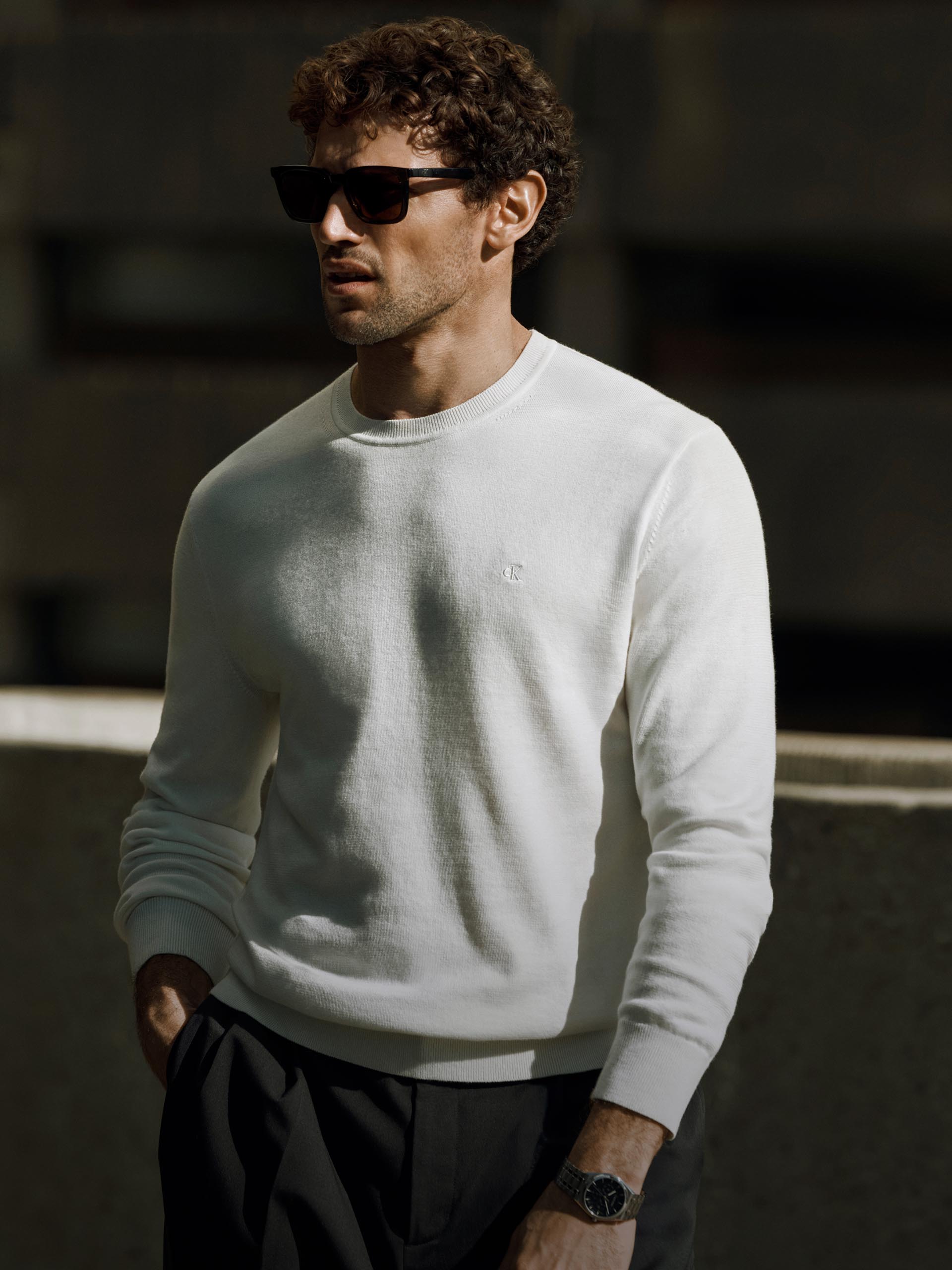 Model posing in a white sweater