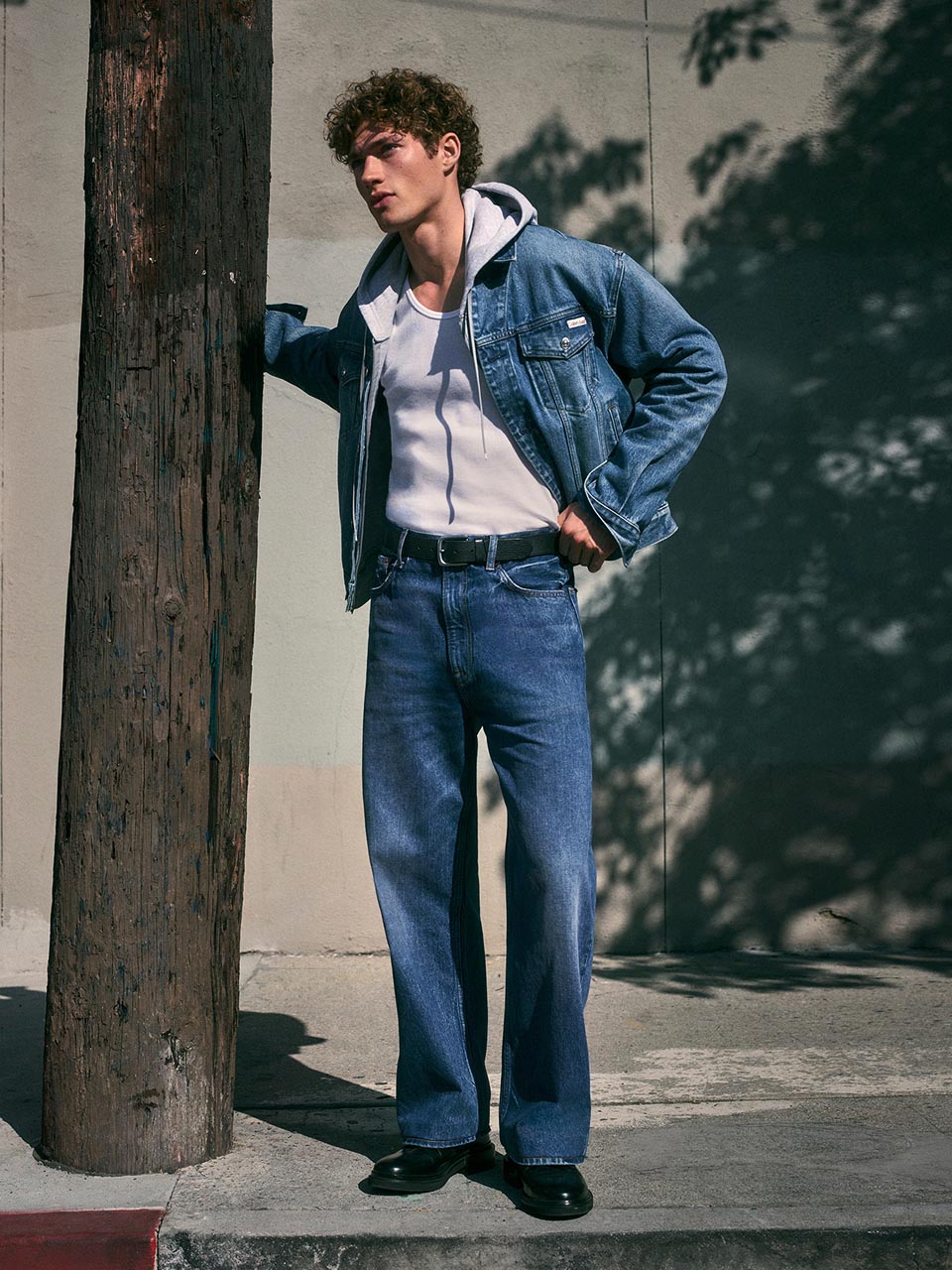 Model posing in a denim jacket and jeans