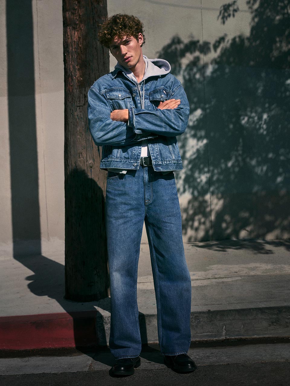 Model posing in a denim jacket and jeans