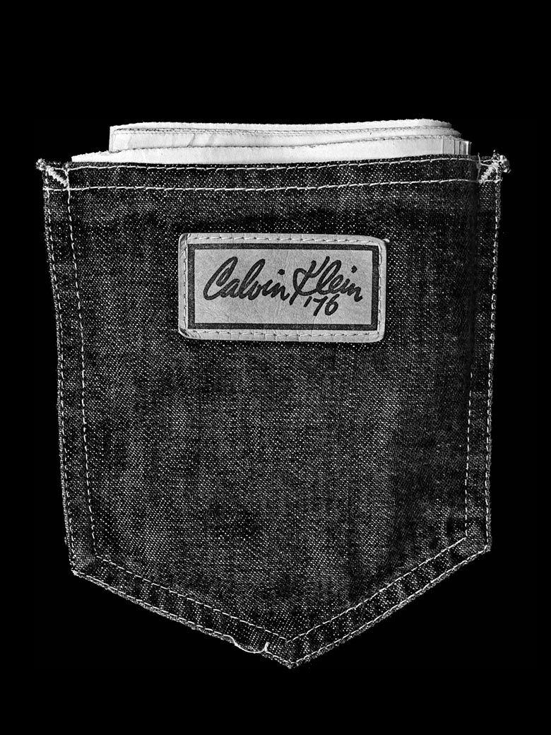 Still life image of the back pocket of black denim jeans