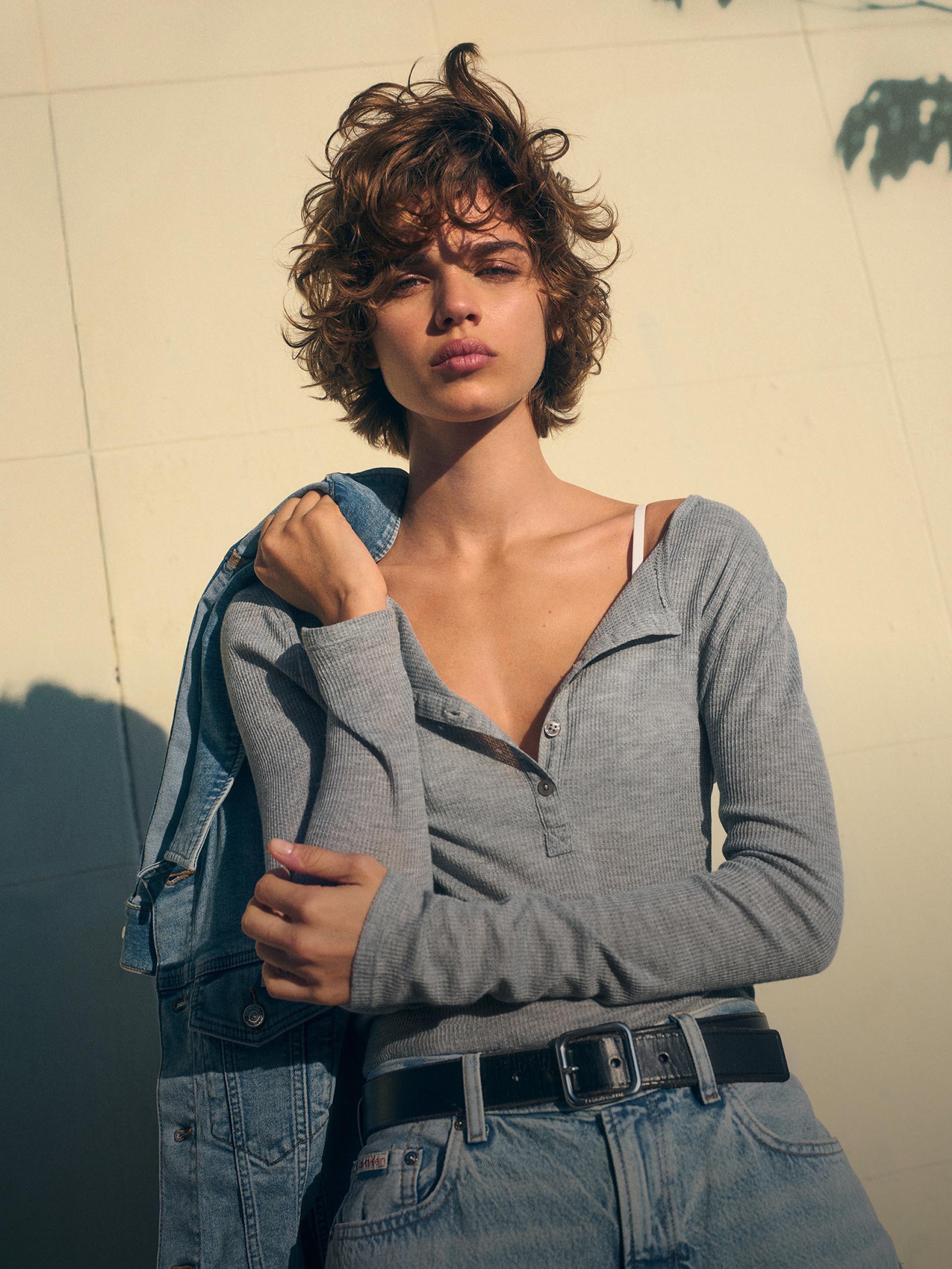 Model posing in a blue button down shirt