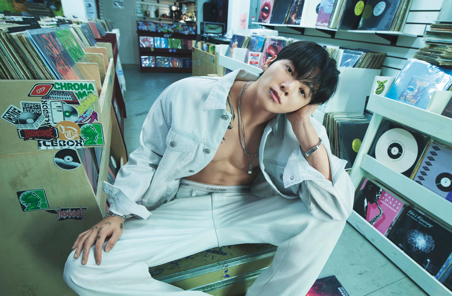 Jung Kook posing in a light wash denim jacket and jeans