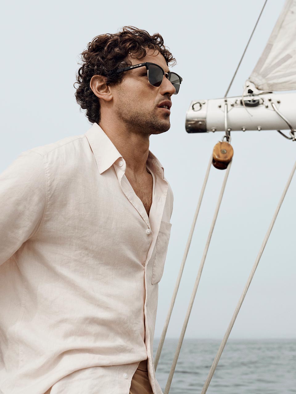 Model posing in a white linen button down shirt