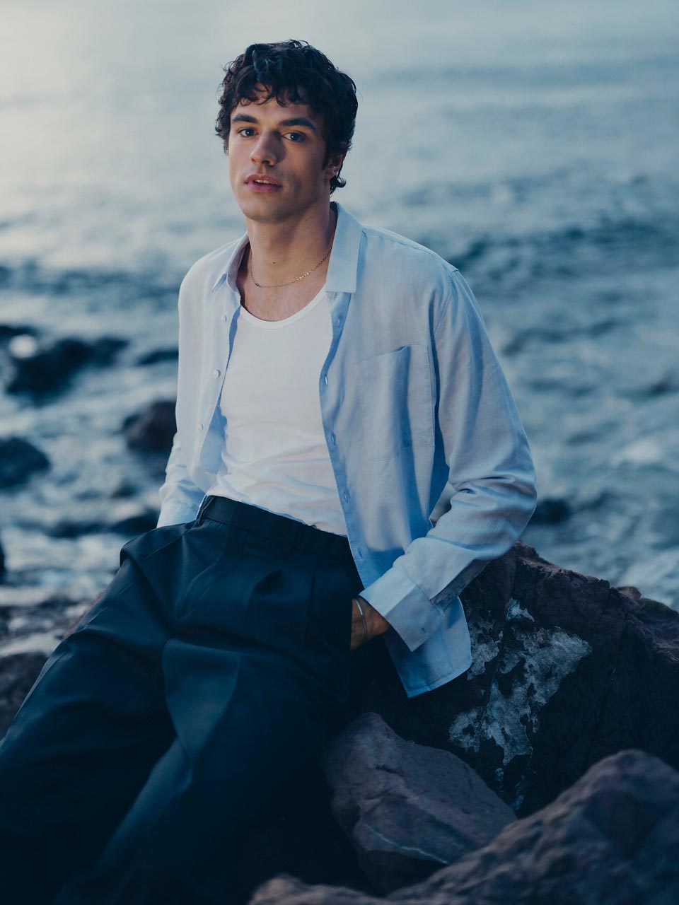 Model posing in a blue linen button down shirt