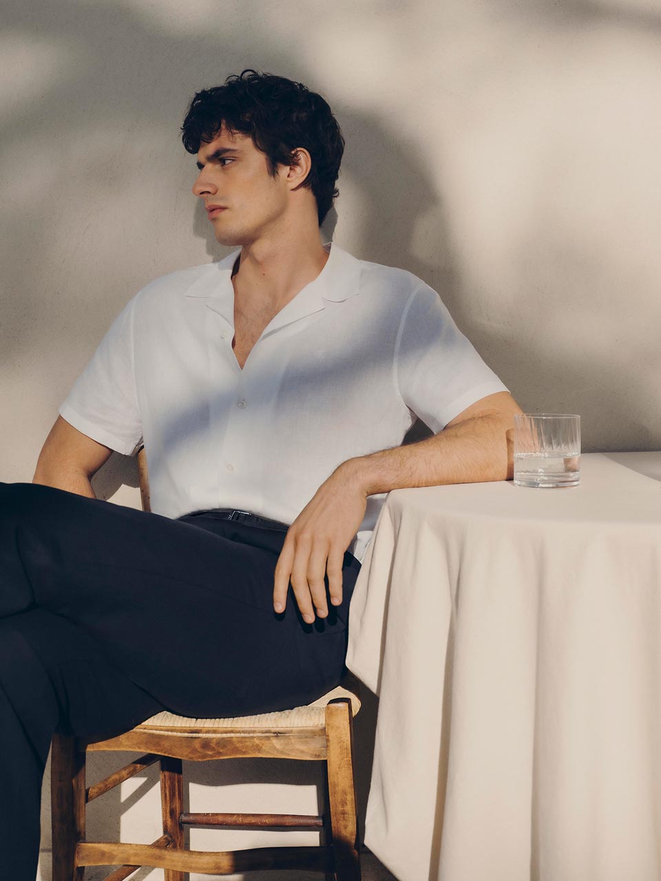 Model posing in a white short sleeve button down shirt