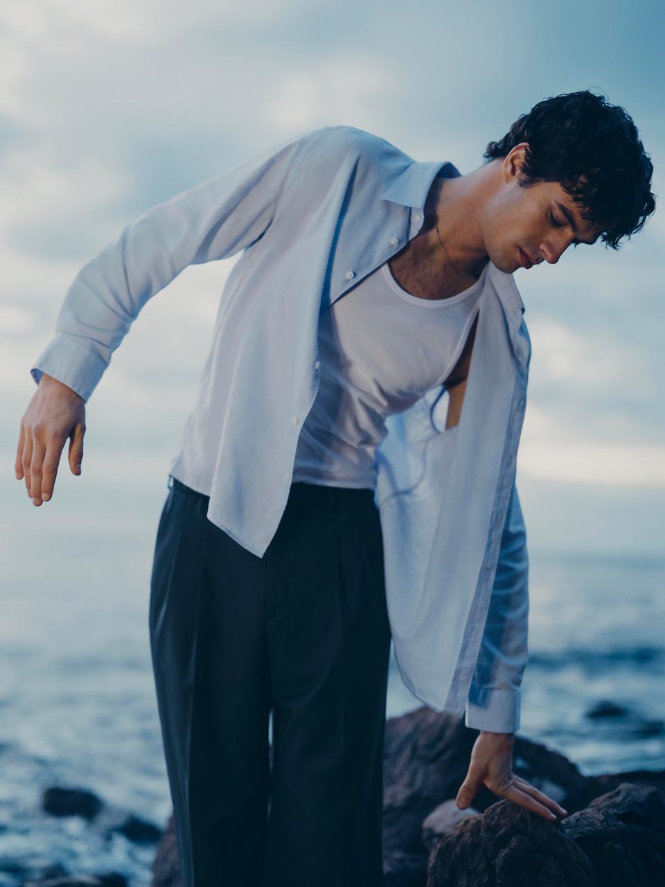 Model posing in a blue linen button down shirt