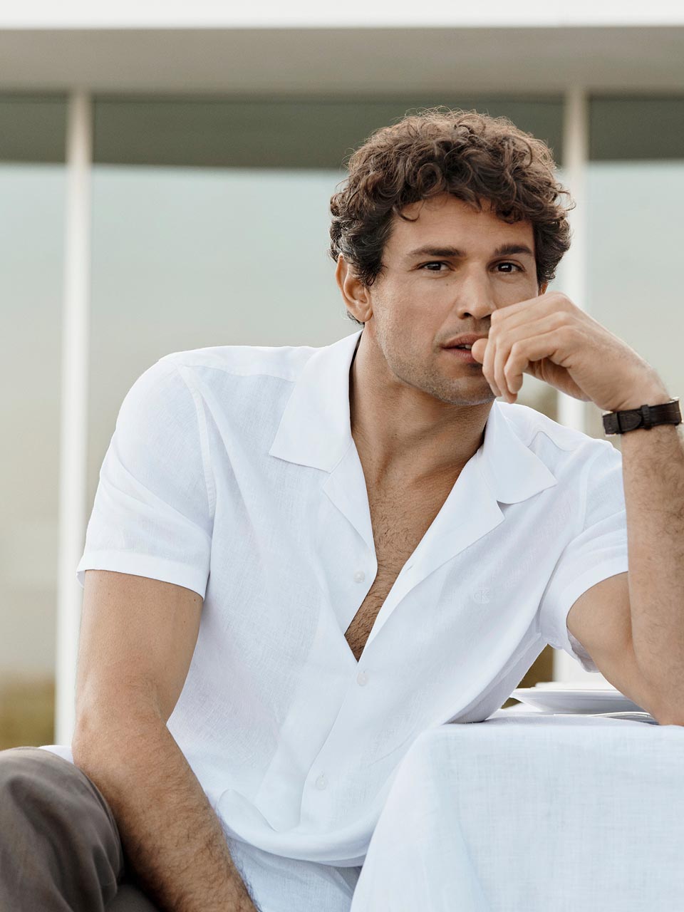 Model posing in a white linen shirt